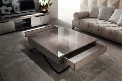 Geometric square cocktail table with a luxury finish acting as a central anchor for seating.